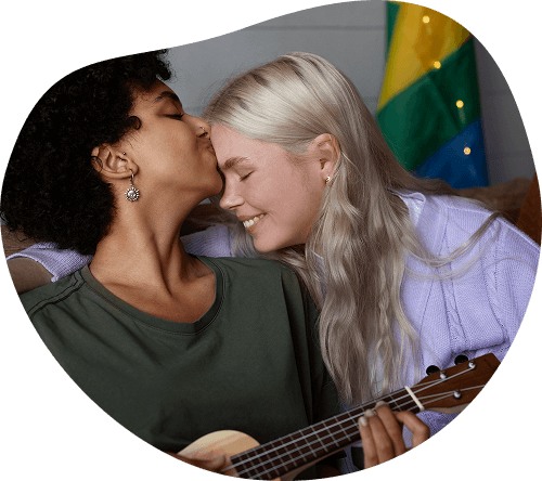 Photo d'un couple, l'une des femmes fait un bisou sur le front de sa compagne